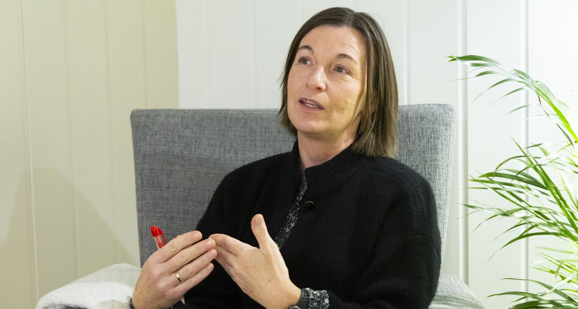Lisbeth sitter i en stol og ser på kamera mens hun snakker